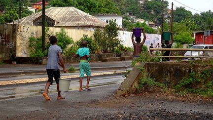 Des enfants transportent des bidons d'eau à Mayotte, en décembre 2016. (ORNELLA LAMBERTI / AFP)