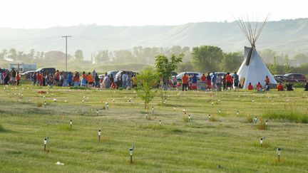 Un hommage est rendu sur le site de la détection de 751 tombes anonymes, marquées par des drapeaux et des lampes, près d'un ancien pensionnat catholique pour autochtones à Marieval (Canada), le 26 juin 2021. (MARK TAYLOR/AP/SIPA)