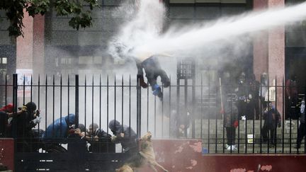 Un &eacute;tudiant est touch&eacute; par un jet de canon &agrave; eau lors d'une manifestation &agrave; Santiago (Chili), le 26 juin 2013. (REUTERS)