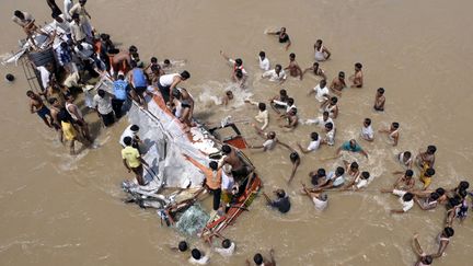 Des hommes tentent de secourir des passagers d'un bus tomb&eacute; accidentellement dans la rivi&egrave;re Puma &agrave; 600 km de Bombay (Inde), le 26 septembre 2012. (REUTERS)