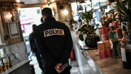 Un policier inspecte un bar, à Paris, pendant une patrouille de contrôle du respect des règles sanitaires, le 3 février 2021. (STEPHANE DE SAKUTIN / AFP)