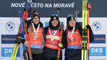 Julia Simon (au centre) fête sa victoire lors de la poursuite aux mondiaux de biathlon en République Tchèque (JOE KLAMAR / AFP)
