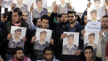 Des manifestants tiennent des portraits du pilote jordanien assassin&eacute; par l'Etat islamique, lors d'une manifestation &agrave; Amman (Jordanie), mardi 3 f&eacute;vrier 2015.&nbsp; (KHALIL MAZRAAWI / AFP)