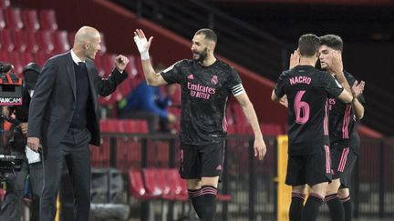 Zinédine Zidane congratule Karim Benzema lors de la victoire du Real Madrid à Grenade (1-4) le 13 mai 2021 en Liga (JORGE GUERRERO / AFP)