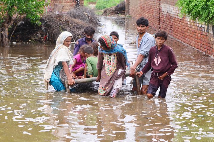 Des habitants d'un village évacuent une zone inondée de la province du Sindh (Pakistan), le 25 août 2022. (CHINE NOUVELLE/SIPA / XINHUA)