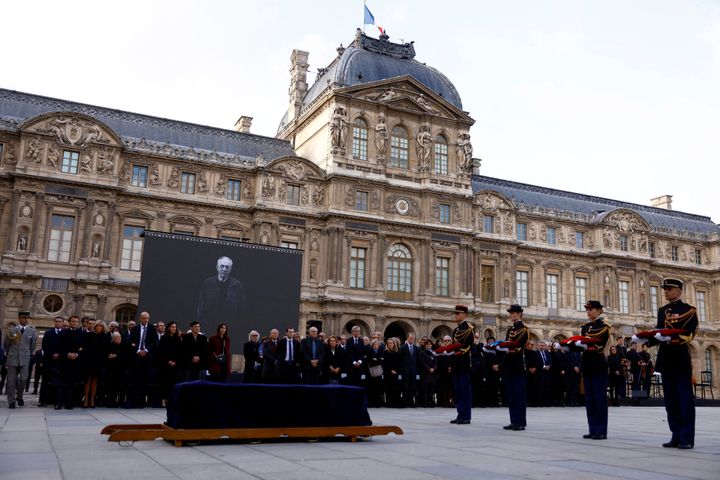 Le président Emmanuel Macron en compagnie de sa femme et de la veuve du peintre Pierre Soualges, décédé à 102 ans lors&nbsp;de l'hommage national&nbsp;dans la Cour du Louvre, accompagné par la Garde républicaine (CHRISTIAN HARTMANN / POOL)