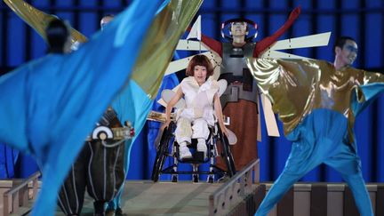 La cérémonie, au thème annoncé "Nous avons des ailes",&nbsp;a recréé un aéroport dans le Stade national pour les besoins de son histoire : un avion à une seule aile, interprété par une adolescente de 13 ans en fauteuil roulant, finissant par trouver les airs. (SHOHEI IZUMI / YOMIURI / AFP)