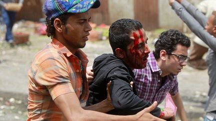 Des manifestants contre l'arm&eacute;e au pouvoir &eacute;vacuent un homme bless&eacute;, au Caire (Egypte), le 2 mai 2012. (KHALED DESOUKI / AFP)