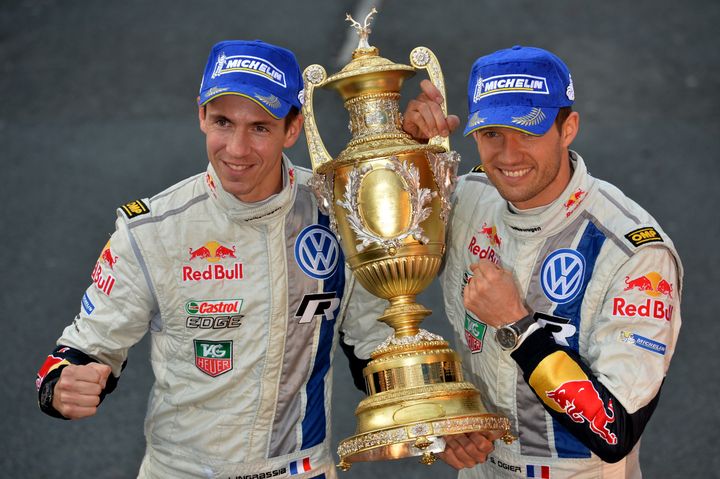 17 novembre 2013, pays de Galles. Vainqueurs du rallye de Grande-Bretagne, Julien Ingrassia et Sébastien Ogier célèbrent leur premier sacre mondial en WRC. (BEN STANSALL / AFP)