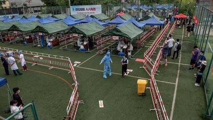 Des personnes patientent pour un dépistage au Covid-19 de grande ampleur, le 24 juin 2020 à Pékin (Chine). (NICOLAS ASFOURI / AFP)