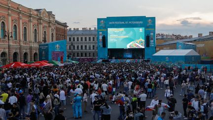 Des supporters russes regardent en direct le match de championnat de l'Euro 2021 entre la Russie et la Belgique le 12 juin 2021, dans la fan zone de la place Konyushennaya à Saint-Pétersbourg, en Russie. (MIKE KIREEV / AFP)