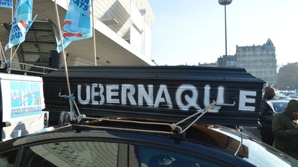 Un cercueil portant l'inscription "Ubernaque" est fixé sur un VTC, pendant le blocage de la porte Maillot, à Paris, le 15 décembre 2016. (ALPHA CIT / CITIZENSIDE / AFP)