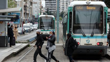 Des personnes passent devant la voie de tramway à Bobigny (Seine-Saint-Denis), le 6 avril 2022, à quelques mètres de l'endroit où Jeremie Cohen a été percuté le 16 février 2022. (THOMAS COEX / AFP)