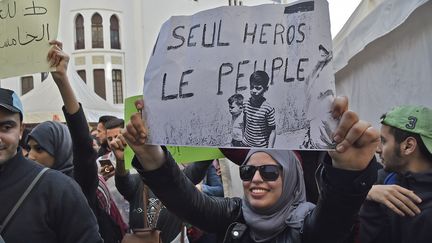 "Un seul héros le peuple" est un slogan célèbre en Algérie issu de cette photo historique prise à Alger en juillet 1962 et brandie par cette manifestante, le 5 mars, à Alger. (RYAD KRAMDI / AFP)