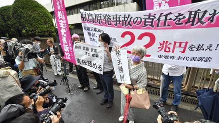 Des plaignants dans le procès intenté par des actionnaires de Tepco&nbsp;après la catastrophe de Fukushima, manifestent devant le tribunal de Tokyo, le 13 juillet 2022. (KAZUHIRO NOGI / AFP)