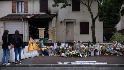 Deux passantes se recueillent devant le domicile de la victime, Chahinez B., brûlée vive par son mari le 4 mai 2021 à Mérignac (Gironde). (STEPHANE DUPRAT / AFP)