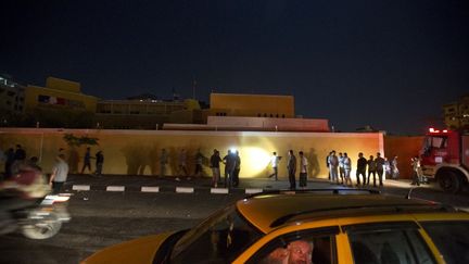 Des passants et des policiers devant le centre culturel fran&ccedil;ais de Gaza, touch&eacute; par un incendie, le 8 octobre 2014. (MAHMUD HAMS / AFP)