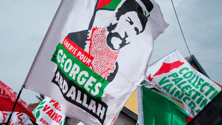 Drapeaux à l'effigie de Georges I. Abdallah lors d'une manifestation pour sa libération devant la prison de Lannemezan où il est incarcéré, le 6 avril 2024. (Antoine Berlioz / Hans Lucas via AFP)