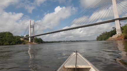 Une pirogue navigue sur le fleuve Oyapock, fronti&egrave;re naturelle entre la Guyane et le Br&eacute;sil, le 27 juillet 2012 pr&egrave;s de Saint Georges de l'Oyapock. Manoelzinho, chef d'une bande suspect&eacute;e par les autorit&eacute;s d'avoir tu&eacute; deux militaires fran&ccedil;ais, a &eacute;t&eacute; arr&ecirc;t&eacute; le 27 juillet sur la rive de l'Amazone. (JEROME VALLETTE / AFP)