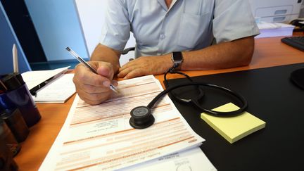 Un médecin prescrit un arrêt de travail. Photo d'illustration. (LIONEL VADAM  / MAXPPP)