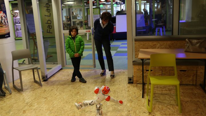 Janine Hofmann regarde le petit robot Nao danser, pendant que son petit-fils le programme sur ordinateur. Cit&eacute; des sciences (Paris), mai 2015. (VALENTINE PASQUENOONE / FRANCE 2)