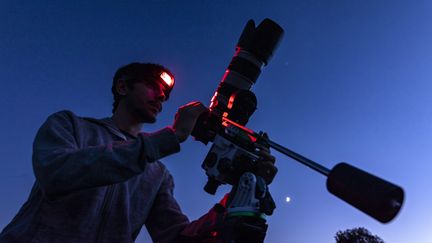 Un homme se prépare à photographier le ciel étoilé. Photo d'illustration. (FLORIAN LAUNETTE & M?GANE CH?NE / MAXPPP)