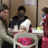 Une famille est en entretien avec des membres de l'ONG France Terre d'asile dans le "hub" du parc des expositions, à Paris,&nbsp;le 18 mars 2022. (ELOISE BARTOLI / FRANCEINFO)