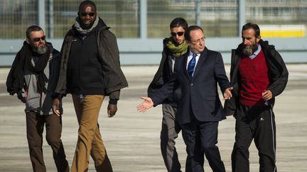 Fran&ccedil;ois Hollande entour&eacute; des quatre ex-otages du Niger, (de gauche &agrave; droite) Marc Ferret, Thierry Dol, Pierre Legrand et Daniel Larribe, le 30 octobre 2013 &agrave; Villacoublay. (  MAXPPP)