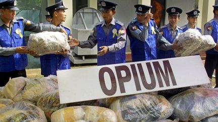 Des paquets contenant de l'opium saisi, aux mains des agents de sécurité du Myanmar, le 26 juin 2006. (KHIN MAUNG WIN / AFP FILES / AFP)