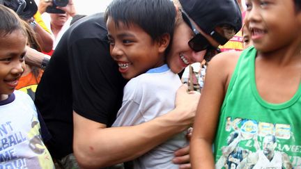 Le chanteur canadien Justin Bieber (C) enlace un jeune survivant du typhon Haiyan &agrave; Palo (Philippines), le 10 d&eacute;cembre 2013. ( AFP)