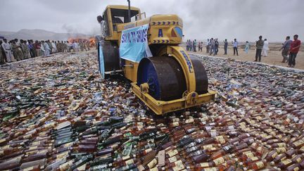 Destruction de bouteilles d'alcools lors de la&nbsp;Journ&eacute;e Internationale contre l'abus et le trafic illicite de drogues &agrave; Karachi (Pakistan), le 26 juin 2012. (AKHTAR SOOMRO / REUTERS)