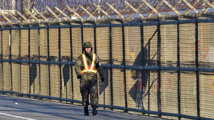 Un soldat sud-coréen marchant le long d'un clôture à la frontière avec la Corée du Nord, le 7 janvier 2016. (JUNG YEON-JE / AFP)