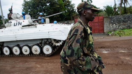 Un rebelle du M23 passe paisiblement devant un blind&eacute; des Nations unies, &agrave; Goma (R&eacute;publique d&eacute;mocratique du Congo), le 20 novembre 2012. (PHIL MOORE / AFP)