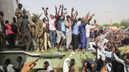 Des manifestants anti-régime lèvent les bras en l'air à Khartoum (Soudan), le 11 avril 2019, après la destitution du&nbsp;président Omar el-Béchir. (AFP)