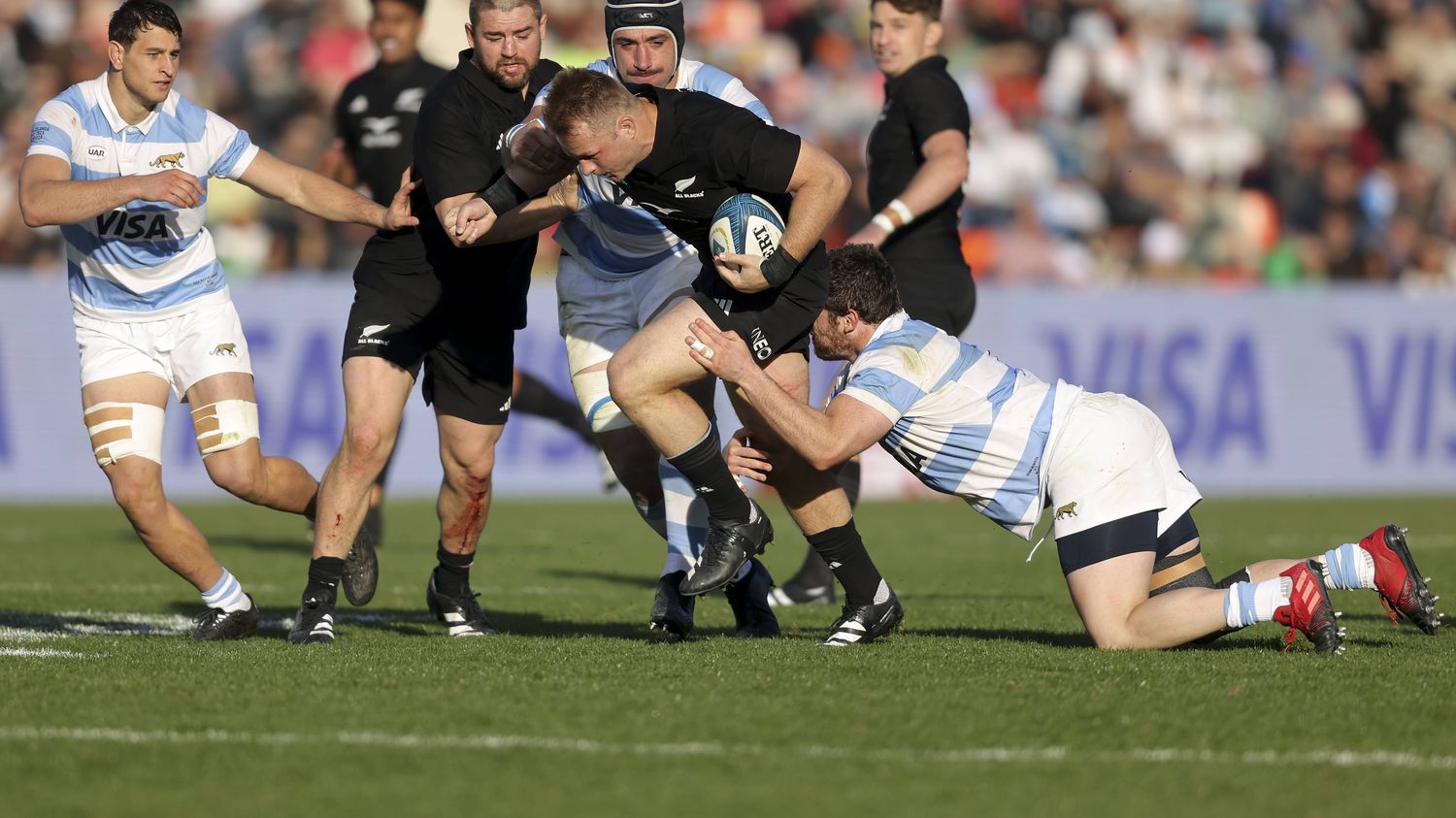 New Zealand captain Sam Keane tackles a spectator on the field and then apologises