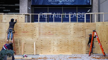 Des commerçants près de la Maison Blanche, à Washington (Etats-Unis), barricadent leur magasin, le 1er novembre 2024, craignant des violences après les résultats de l'élection américaine. (BRYAN DOZIER / NURPHOTO / AFP)