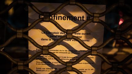 Un message expliquant les modalités de commande en ligne sur la vitrine d'une librairie parisienne, fermée pendant le confinement, le 9 novembre 2020. (AMAURY CORNU / HANS LUCAS / AFP)