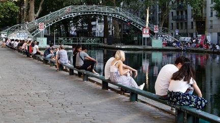 Des parisiens profitent du Canal Saint Martin pendant la canicule, le 23 juillet 2019 (FRANCOIS GUILLOT / AFP)