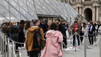 Des visiteurs attendent devant le musée du Louvre, le 19 mai 2021. (ALAIN JOCARD / AFP)