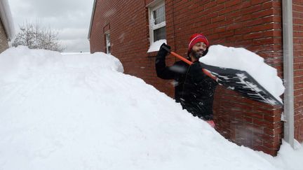 Un habitant d'Erie (Pennsylvanie, Etats-Unis) déneige l'accès à sa maison après des chutes de neige record dans cette ville, le 26 décembre 2017. (GREG WOHLFORD / AP / SIPA)