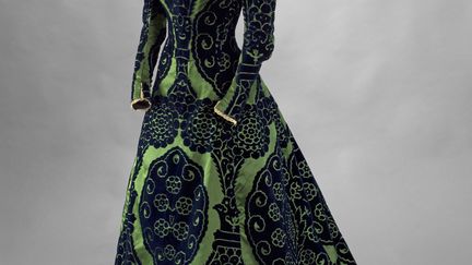 Tout à la fois robe de réception et tenue privée, cette robe d’intérieur a été portée par la comtesse pour recevoir ses amis intimes, en fin d’après-midi - d’où le nom anglais de « tea-gown », ou robe pour prendre le thé, que l’on donne à ce type de pièce. La comtesse choisissait volontiers un vert intense pour ses tenues mettant en valeur l’auburn de sa chevelure. Spectaculaire par ses immenses motifs, cette robe est caractéristique des créations de Jean-Philippe Worth, qui avait succédé en 1895 à son père, Charles Frederick, l’inventeur de la haute couture. Le fils affectionnait les tissus historicisants dont ce velours ciselé imitant les velours de Gênes de la Renaissance est un exemple somptueux.
 (Stéphane Piera / Galliera / Roger-Viollet)