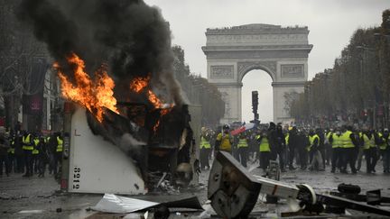 Un véhicule de chantier est incendié sur les Champs-Elysées, le 24 novembre 2018, à Paris, lors d'une manifestation des "gilets jaunes". (BERTRAND GUAY / AFP)