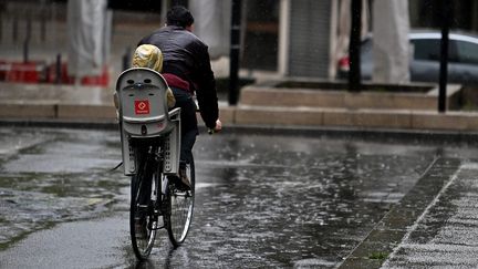 Un cycliste dans les rues pluvieuses de Saint-Etienne (Loire), le 28 avril 2024. (REMY PERRIN / LE PROGRES / MAXPPP)