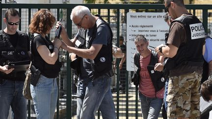 Des policiers s&eacute;curisent l'entr&eacute;e de l'usine Air Products, vis&eacute;e par une attaque, &agrave;&nbsp;Saint-Quentin-Fallavier (Is&egrave;re) le 26 juin 2015.&nbsp; (PHILIPPE DESMAZES / AFP)