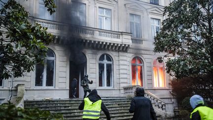 Des "gilets jaunes" entrent dans un hôtel particulier incendié avenue Kléber, le 1er décembre 2018, lors de l'acte III de leur mouvement. (CHRISTOPHE PETIT TESSON / MAXPPP)