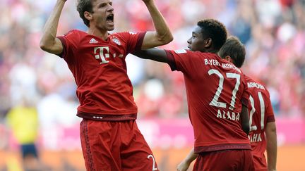 Thomas Müller (à gauche), heureux et accompagné par ses coéquipiers, David Alaba et Philipp Lahm. (CHRISTOF STACHE / AFP)