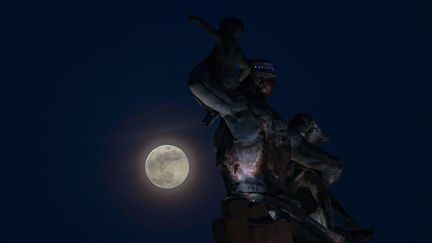 La "Lune du castor" apparaît derrière le Monument de la renaissance africaine, à Dakar, au Sénégal, le 16 novembre 2024. (CEM OZDEL / ANADOLU / AFP)