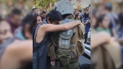 A Santiago (Chili), une manifestante a enlacé un gendarme le 21 octobre 2019. (JUAN ATENAS OROSTICA VIA STORYFUL)