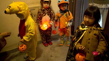 Des enfants d&eacute;guis&eacute;s pour Halloween attendent des bonbons devant la porte d'un appartement &agrave; P&eacute;kin (Chine), le 30 octobre 2013. (ALEXANDER F. YUAN / AP / SIPA)