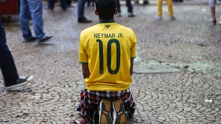 Sonn&eacute; par l'&eacute;limination, ce supporter&nbsp;auriverde qui suivait la rencontre dans les rues de Sao Paulo est incapable de se relever. (MIGUEL SCHINCARIOL / AFP)